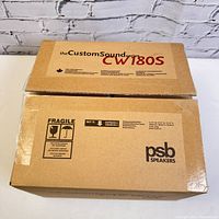 Photos of the unopened original packaging for PSB Custom Sound Series CW180S In-Wall Speaker showing box branding and condition.