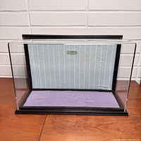 Toy display case set upright showing purple base and patterned vertical back panel