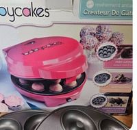 Photo showing Pink Babycakes mini donut maker with donut hole baking plates and box.