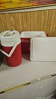 Photo of the two red coolers on a table, showing the jug and cooler box side by side