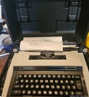 Smith Corona Celebrity Power 12 electric typewriter in hard plastic carrying case with paper loaded.