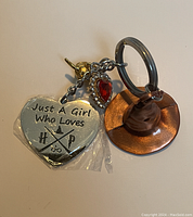 Clear view of the full Harry Potter themed keychain showing the heart charm with saying, the flying key charm, the red gem charm, and the Sorting Hat charm.