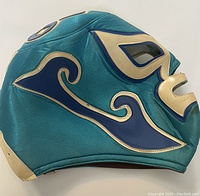 Side view detail showing blue and cream applique on teal shiny fabric.