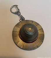 Front view of the Straw Hat metal key chain showing detailed texture and red band.