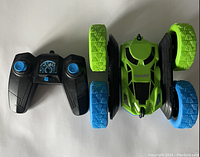 Top view of green and blue RC stunt car alongside its black and blue 2.4G wireless remote controller