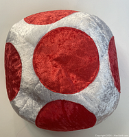 Front view of plush cap resembling Toad's mushroom head with red spots on white background.
