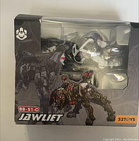 Front view of the original packaging showing the robotic animal toy inside a clear plastic window, box artwork includes images of the robot's animal form and mechanical details.