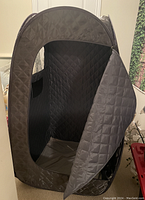 Portable sauna tent open showing interior quilted lining and zippered entry.