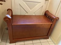 Front view of entire wooden storage bench showing overall form and finish