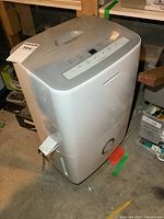 Frigidaire dehumidifier, side and top view showing control panel with digital display and buttons.