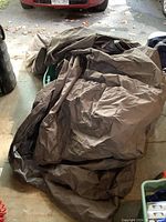 Furniture covers and large tote laid on floor showing fabric textures and colors