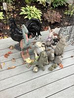 Wide view showing all figures on deck with plants in background.