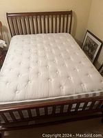 Front view of assembled queen sleigh bed frame with mattress showing slatted headboard and footboard