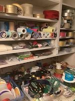 Shelves filled with numerous spools of ribbons in multiple colors and materials including glitter and metallic finishes.