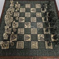 Full view of the Aztec chess board with all chess pieces set on it, showing the board's detailed pattern and the design of the pieces.