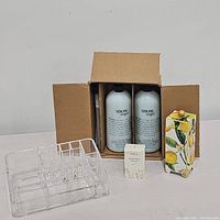Full view of all items including Snow Angel bottles in original box, Grove soap, lemon basil lotion, and makeup organizer