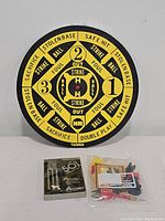 Photo of vintage double sided baseball dart board with black and yellow design marked with baseball terms, standing upright.