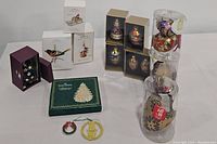 Wide shot of all ornaments included showing boxed Hallmark Keepsake ornaments, clear tubes with various ornaments, green box, and loose ornaments.
