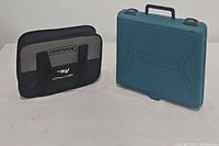 Two tool cases side by side: a Craftsman fabric soft case labeled 12V and a teal Makita hard case.