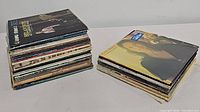 Two stacks of vintage vinyl records, showing the variety and number of records included in the lot