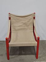 Front view of the safari chair showing off-white canvas seat and red wood legs and frame.
