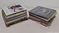 Two stacks of vintage vinyl albums, showing album covers and edges, revealing a diverse collection in used condition.