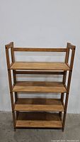 Front view of the 4-shelf wooden foldable bookshelf showing all shelves and wooden side supports.