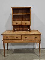 Front view of wooden desk/sideboard with two drawers and separate wooden hutch cabinet with two small drawers and shelving, shown stacked.