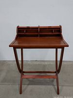 Front view of desk with roll top open, showing compartments for organization and foldable leg design