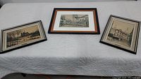 All three framed prints laid out on table showing different Parisian street scenes by Paul Lambert.