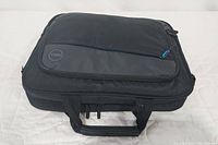 Black Dell laptop carrying case closed, showing Dell round logo on front.