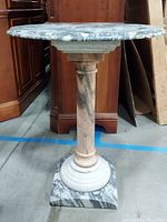 Full front view showing round marble top on turned column and square base