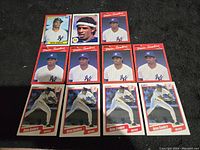 Photo showing 11 Dion Sanders baseball cards laid out on a dark surface, featuring multiple card designs including several with red borders and Yankees uniform.