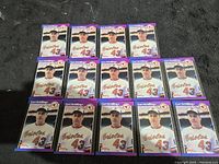 Photo of 14 identical Curt Schilling rookie baseball cards showing the front side of the cards with a purple border and him in Orioles attire.