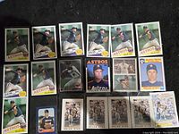Photo showing multiple Nolan Ryan baseball cards, mostly Houston Astros in pitching poses, dated 1985-1986, some labeled Record Breaker.