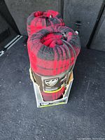 Two rolled red and black plaid electric heated blankets inside cardboard packaging, showing AutoDrive brand and travel blanket label.