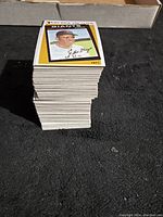 Tall stack of 1986 Topps Baseball cards seen from the top, showing one card with a baseball player portrait and autograph facsimile.