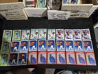 Thirty Ken Griffey Jr. baseball cards laid out showing assortment of designs and colors in Mariners uniforms.