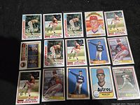 Photo showing 15 Nolan Ryan baseball cards from 1981 and 1982 laid out on a black surface, including Highlight and standard Topps cards in various poses.