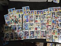 Spread of about fifty 1984 Topps baseball cards showing front images and player portraits.