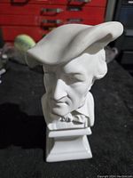 White porcelain bust of Richard Wagner wearing a large hat, front view