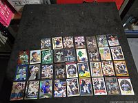 Wide view of 32 Mike Piazza baseball cards laid out on black cloth showing front sides with various designs and poses