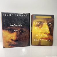 Photo of the front covers of the two art books: 'Rembrandt's Eyes' by Simon Schama and 'Leonardo Da Vinci' by Walter Isaacson, showing their dust jackets.