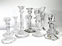 Wide view showing all eight crystal candle holders with varying heights and designs.