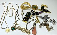 Collection of vintage jewelry including bracelets, necklaces, pins, earrings, and cufflinks displayed on white background.