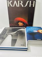 Three photography books arranged showing covers: 'Karsh' with black cover and a woman in red hat, 'Bill Brandt Shadow & Light' with black and white cover of a sculpture and 'A History of Photography' with blue surreal cover.