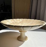 Side profile showing the scalloped design of the bowl and the pedestal foot.
