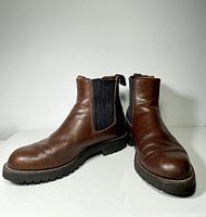 Front view showing round toe, brown leather with moderate creasing and black elastic sides.