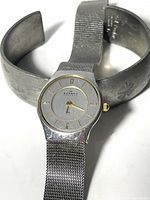 Skagen watch alongside Jyde-Kunst pewter cuff bracelet, showing size and style comparison.