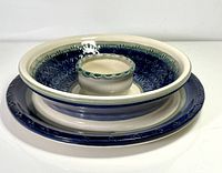 Studio pottery crudité serving bowl showing the top view with blue floral patterned interior and central dip section with green decorative trim.